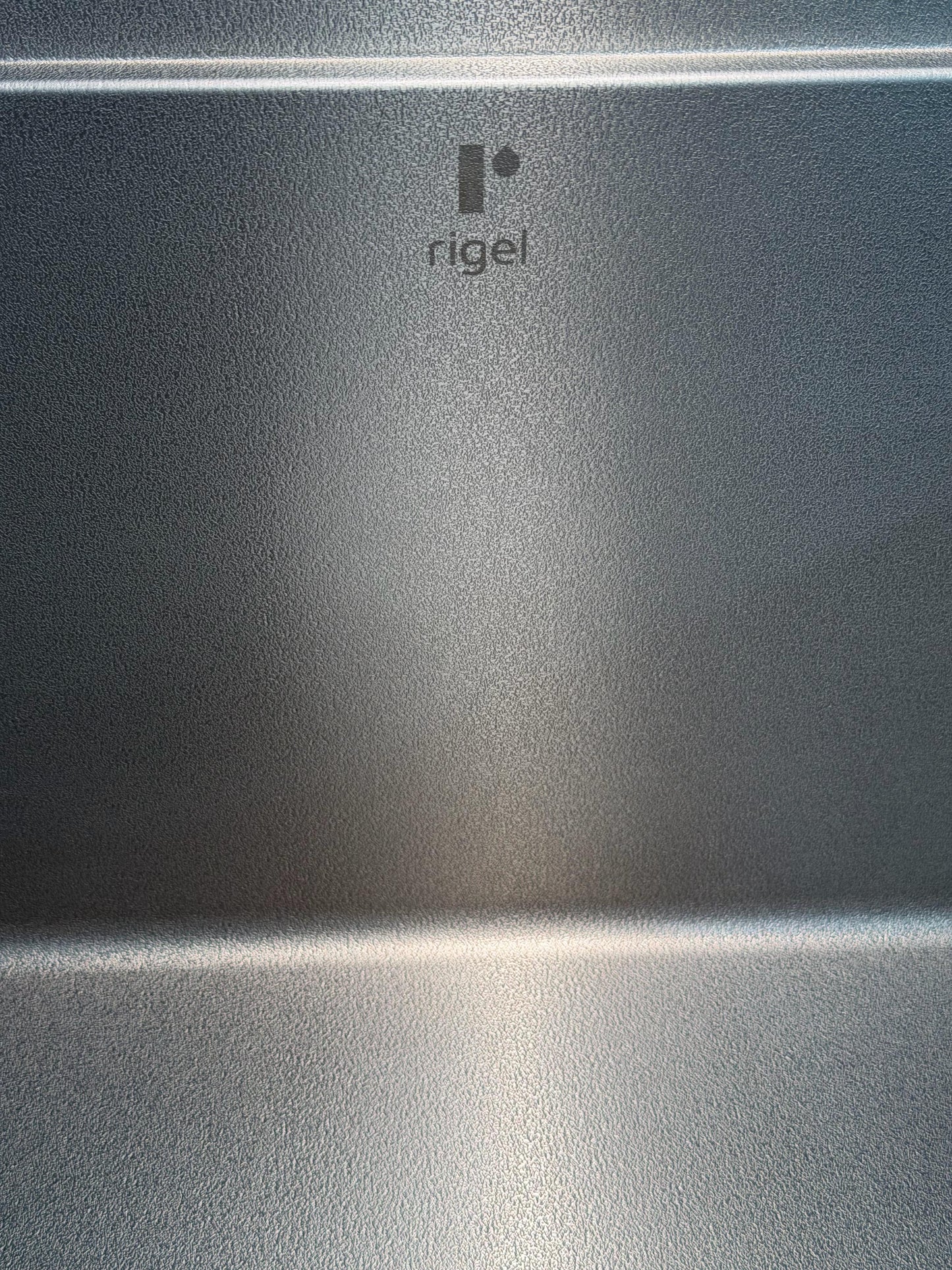 Metallic surface with 'Rigel' logo in the center